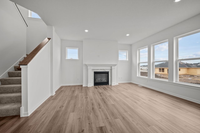 1520 Philipp Way, Shakopee, MN 55379 - unfurnished living room with light wood-style flooring, recessed lighting, stairs, a glass covered fireplace, and baseboards