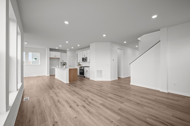 1520 Philipp Way, Shakopee, MN 55379 - unfurnished living room with recessed lighting, light wood-style flooring, a sink, baseboards, and stairway