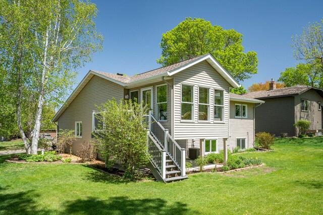 1944 Linda Ln, Saint Cloud, MN 56301 - back of house featuring a yard, stairway, central AC unit, and a shingled roof