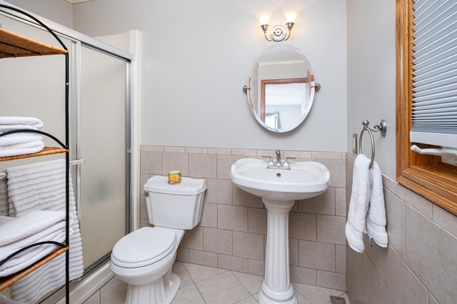 1944 Linda Ln, Saint Cloud, MN 56301 - bathroom with tile walls, a shower stall, tile patterned flooring, a wainscoted wall, and toilet