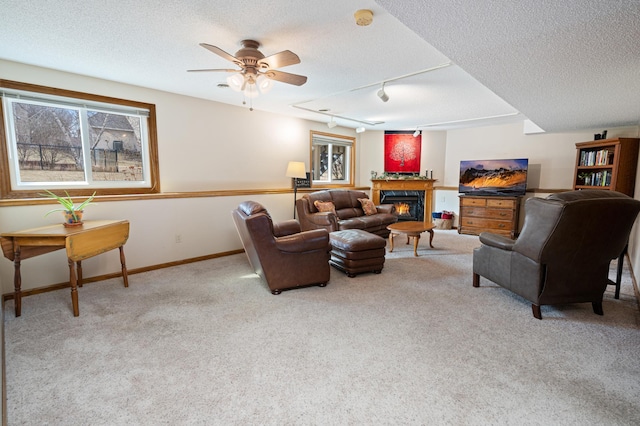 1944 Linda Ln, Saint Cloud, MN 56301 - living room with light colored carpet, a textured ceiling, a lit fireplace, a ceiling fan, and track lighting