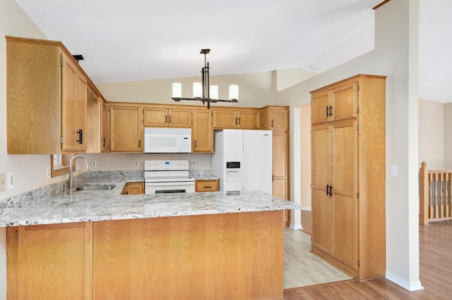 kitchen with a chandelier, light wood-style flooring, a peninsula, white appliances, and a sink