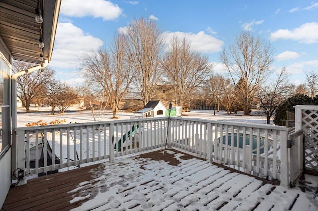 snow covered deck featuring a swimming pool and an outdoor structure