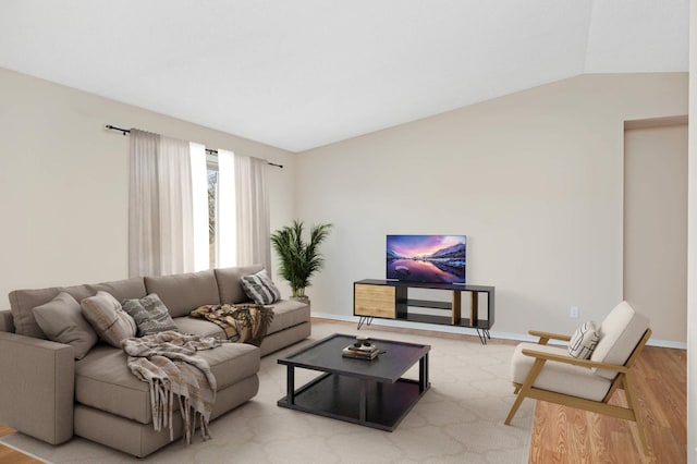 living area featuring light wood-type flooring, baseboards, and vaulted ceiling