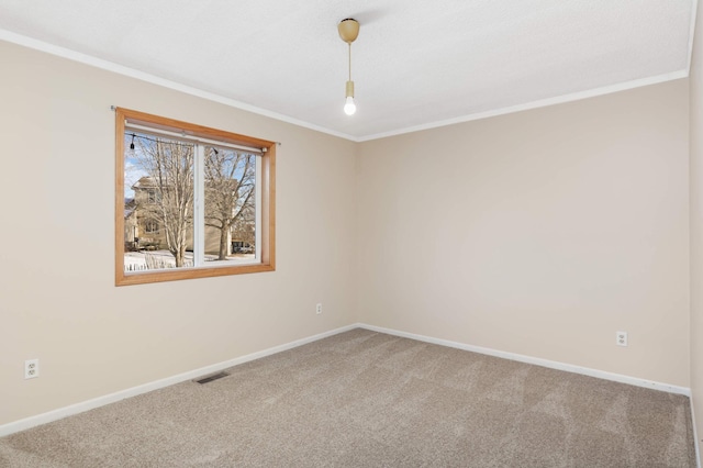 carpeted spare room with crown molding, baseboards, and visible vents
