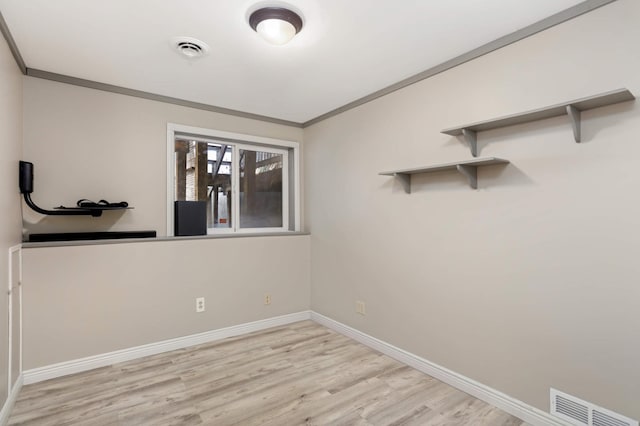 empty room with visible vents, ornamental molding, baseboards, and wood finished floors