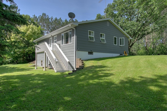 view of home's exterior with a garage, a lawn, and stairs