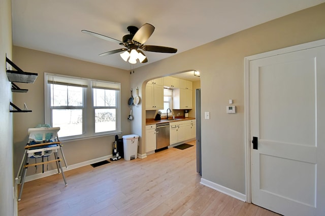 2604 Clearwater Rd, Saint Cloud, MN 56301 - kitchen with light wood finished floors, a ceiling fan, arched walkways, dishwasher, and white cabinetry