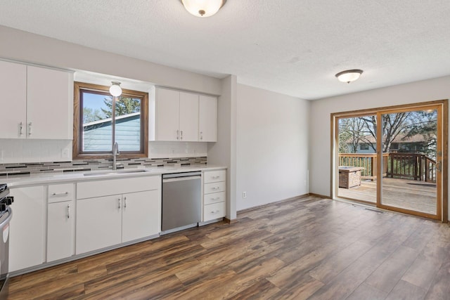 kitchen featuring a textured ceiling, tasteful backsplash, a sink, light countertops, and stainless steel appliances