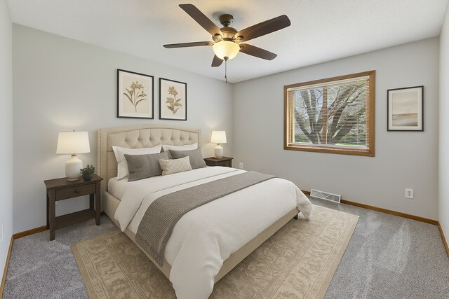 bedroom featuring baseboards, visible vents, and light carpet