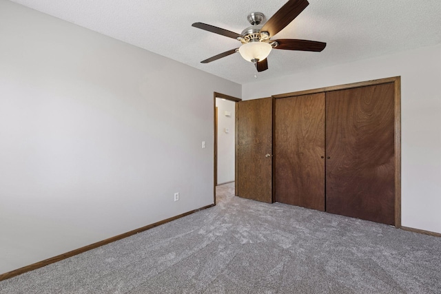 unfurnished bedroom featuring baseboards, ceiling fan, carpet, and a closet