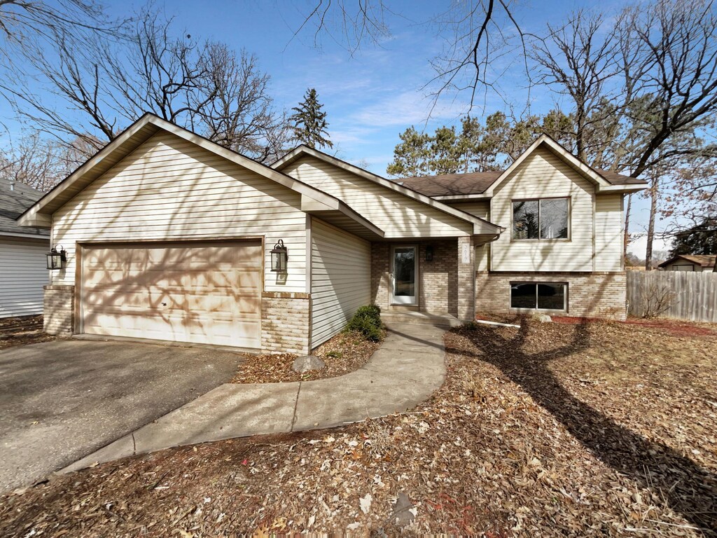 3617 141st Ln NW, Andover, MN 55304 - split level home with aphalt driveway, an attached garage, fence, and brick siding