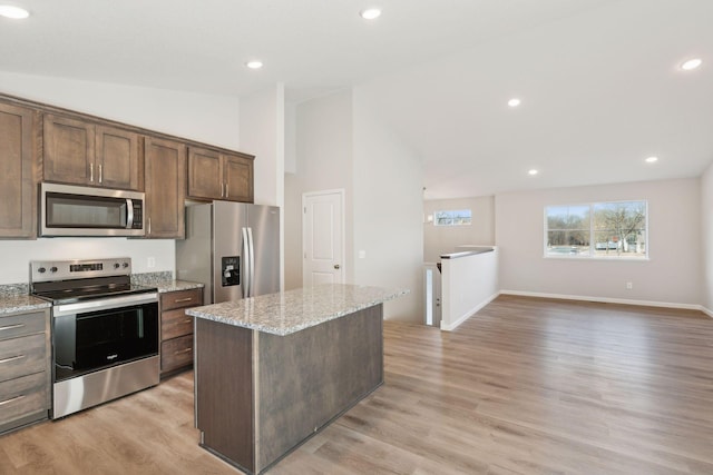 224 9th Ave Ct NW, Lonsdale, MN 55046 - kitchen featuring a center island, light stone countertops, light wood-type flooring, recessed lighting, and appliances with stainless steel finishes