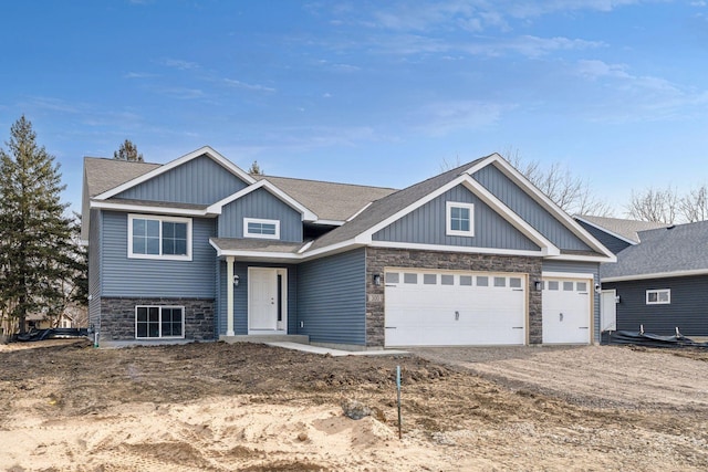 224 9th Ave Ct NW, Lonsdale, MN 55046 - view of front of home featuring stone siding, driveway, a garage, and board and batten siding