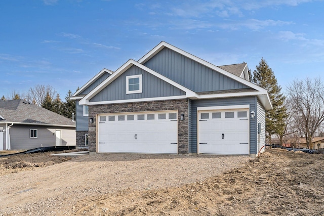 224 9th Ave Ct NW, Lonsdale, MN 55046 - view of front facade featuring board and batten siding, an attached garage, stone siding, and driveway