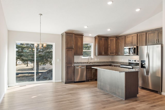 224 9th Ave Ct NW, Lonsdale, MN 55046 - kitchen featuring a notable chandelier, dark stone countertops, stainless steel appliances, light wood finished floors, and vaulted ceiling