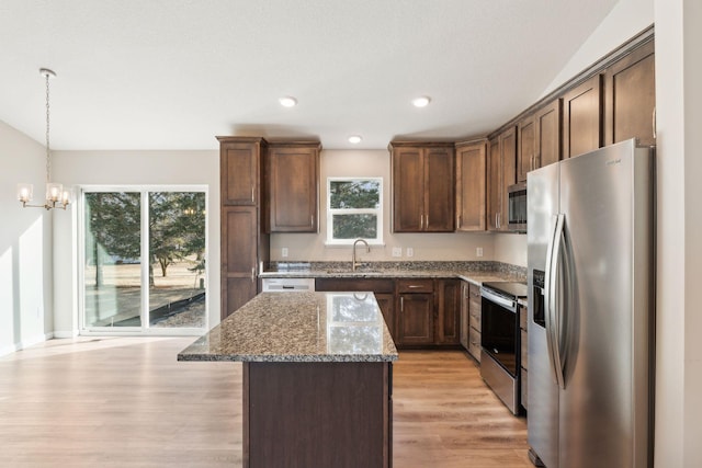 224 9th Ave Ct NW, Lonsdale, MN 55046 - kitchen featuring a center island, dark stone countertops, appliances with stainless steel finishes, an inviting chandelier, and a sink