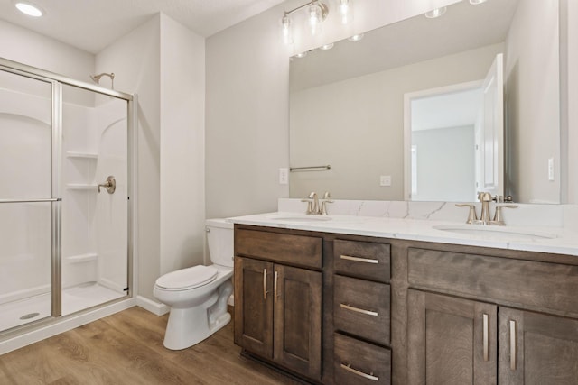 224 9th Ave Ct NW, Lonsdale, MN 55046 - full bathroom with wood finished floors, a stall shower, toilet, and a sink