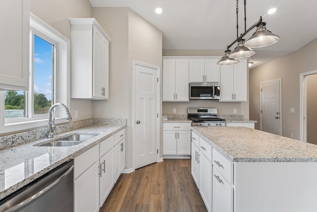 4905 Evergreen Dr N, Hugo, MN 55038 - kitchen with stainless steel appliances, a kitchen island, dark wood finished floors, white cabinets, and hanging light fixtures