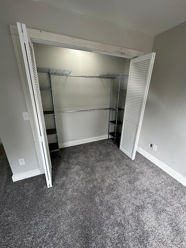 412 Holly Ln, Mankato, MN 56001 - unfurnished bedroom with a closet, dark carpet, and baseboards