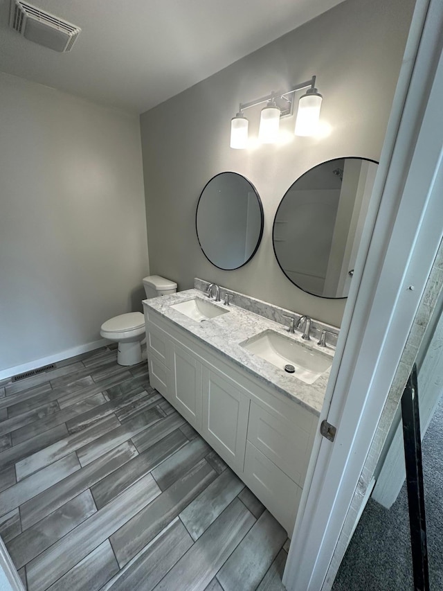 412 Holly Ln, Mankato, MN 56001 - bathroom with a sink, visible vents, toilet, and wood tiled floor