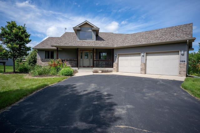 1102 Summit Cv, Dassel, MN 55325 - view of front of property with driveway, a garage, covered porch, brick siding, and a shingled roof