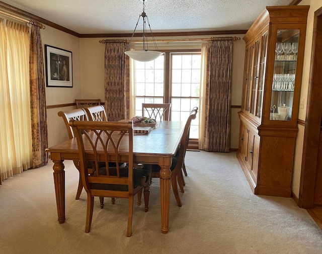 dining area featuring a textured ceiling, light colored carpet, and ornamental molding