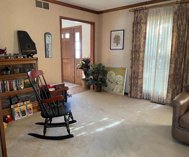 living area featuring carpet flooring, a textured wall, ornamental molding, and visible vents