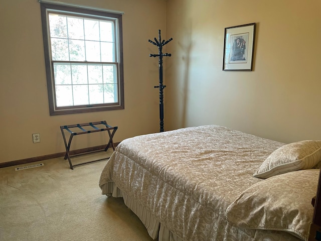 bedroom featuring visible vents, baseboards, multiple windows, and carpet