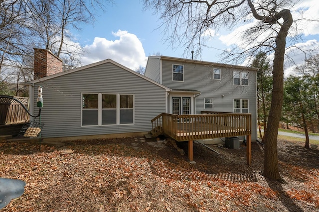 back of house featuring a deck, cooling unit, and a chimney