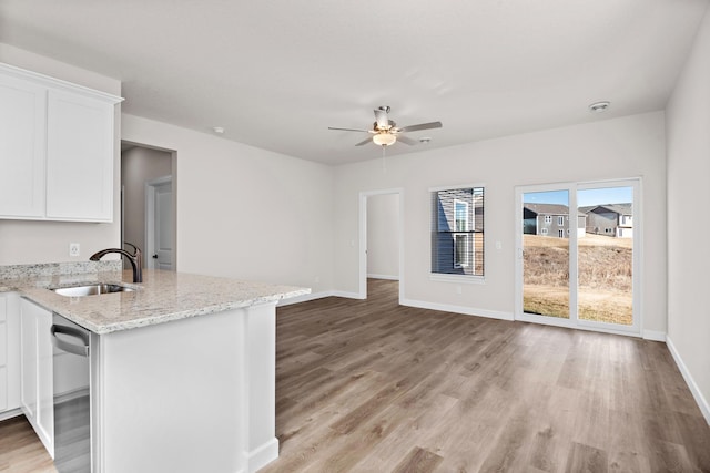 18756 Ivanhoe St NW, Elk River, MN 55330 - kitchen featuring dishwasher, white cabinetry, light wood-style floors, light stone countertops, and a ceiling fan