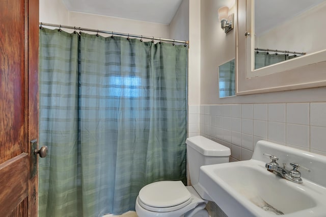 301 7th Ave S, Saint Cloud, MN 56301 - full bathroom with a sink, toilet, tile walls, and a shower with curtain