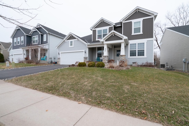 460 14th St NW, New Brighton, MN 55112 - craftsman-style home with covered porch, asphalt driveway, a garage, board and batten siding, and a front yard