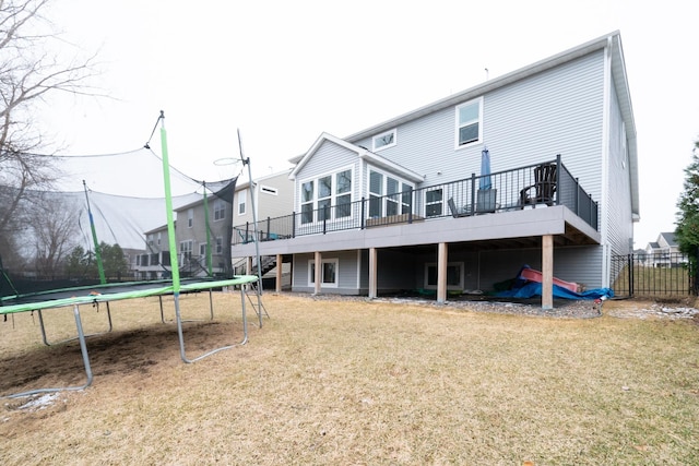 460 14th St NW, New Brighton, MN 55112 - back of property with a trampoline, a yard, and a wooden deck