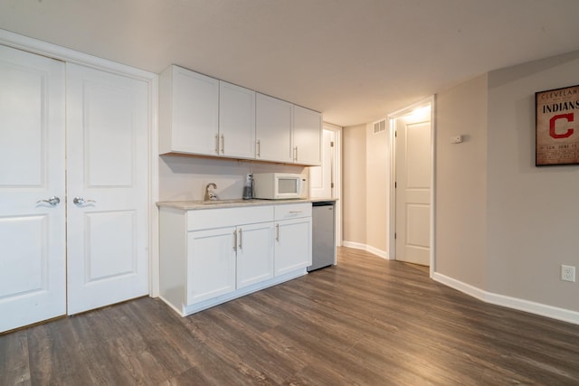 460 14th St NW, New Brighton, MN 55112 - kitchen with white microwave, dark wood-style flooring, dishwasher, and white cabinets