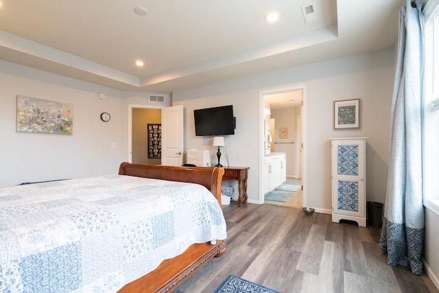 460 14th St NW, New Brighton, MN 55112 - bedroom with wood finished floors, a raised ceiling, baseboards, recessed lighting, and connected bathroom