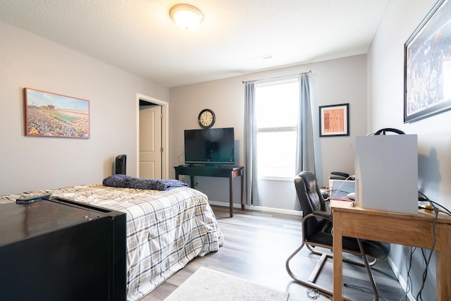 460 14th St NW, New Brighton, MN 55112 - bedroom with light wood-type flooring, a desk, and baseboards