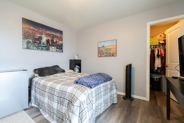 460 14th St NW, New Brighton, MN 55112 - bedroom with wood finished floors, a walk in closet, baseboards, and a closet
