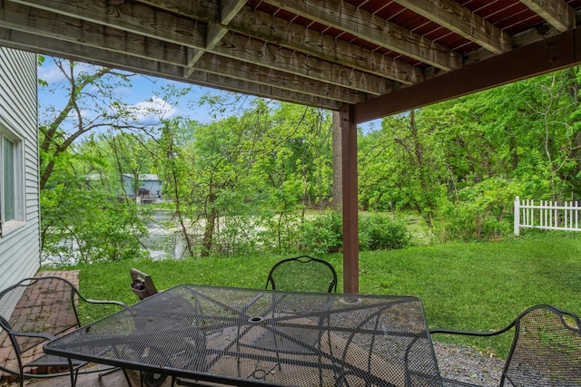 view of patio featuring outdoor dining space and view of wooded area