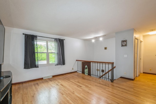 spare room with light wood finished floors and baseboards