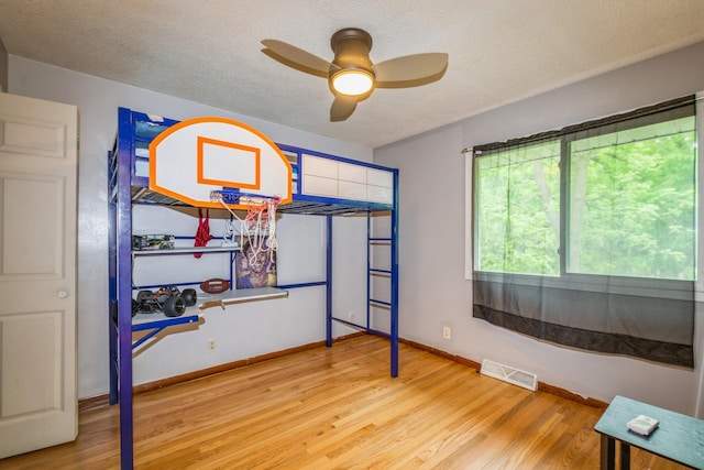 unfurnished bedroom featuring wood finished floors, a textured ceiling, and baseboards