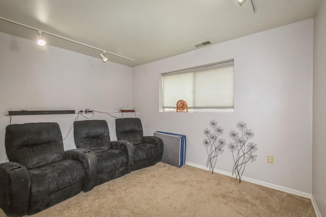 carpeted home theater with rail lighting and baseboards