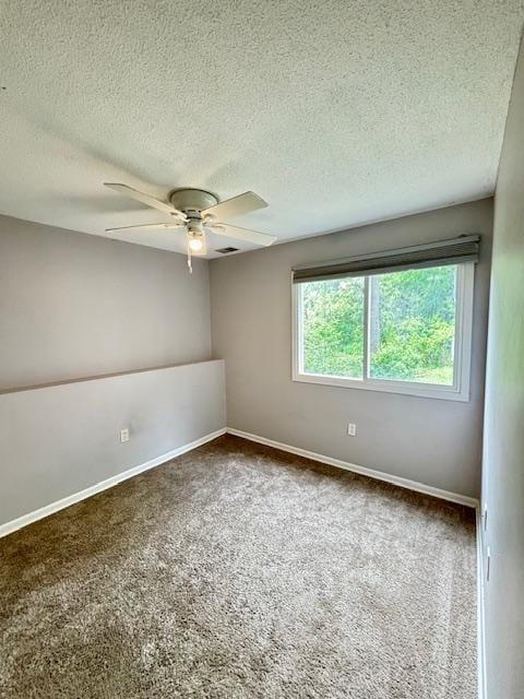 carpeted empty room featuring a ceiling fan, a textured ceiling, and baseboards