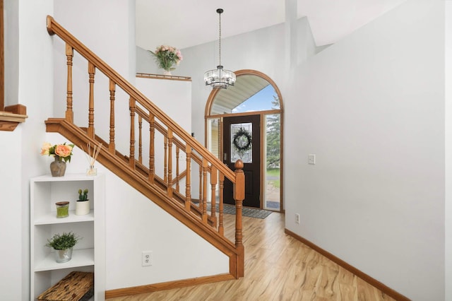2222 Crosstown Blvd NE, Ham Lake, MN 55304 - foyer with wood finished floors, a high ceiling, baseboards, stairs, and a chandelier