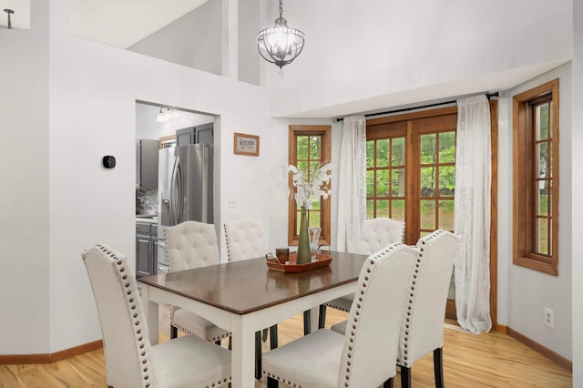 2222 Crosstown Blvd NE, Ham Lake, MN 55304 - dining room with baseboards, light wood-style floors, a chandelier, and a high ceiling