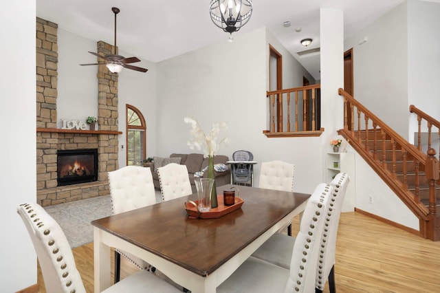 2222 Crosstown Blvd NE, Ham Lake, MN 55304 - dining space featuring wood finished floors, ceiling fan, stairs, a stone fireplace, and baseboards