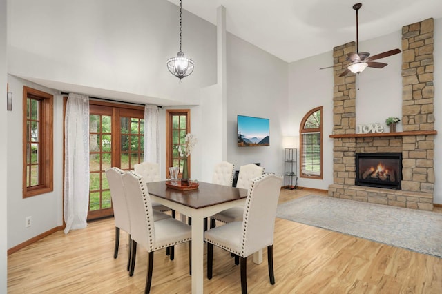 2222 Crosstown Blvd NE, Ham Lake, MN 55304 - dining room featuring light wood finished floors, baseboards, high vaulted ceiling, a fireplace, and ceiling fan