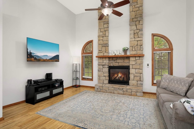 2222 Crosstown Blvd NE, Ham Lake, MN 55304 - living area with high vaulted ceiling, baseboards, a fireplace, ceiling fan, and wood finished floors