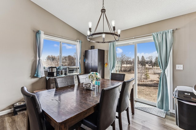 230 Newspaper Run NE, Kimball, MN 55353 - dining space featuring a chandelier, wood finished floors, lofted ceiling, and baseboards