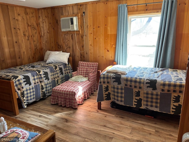 bedroom featuring wood walls, wood-type flooring, and a wall mounted air conditioner